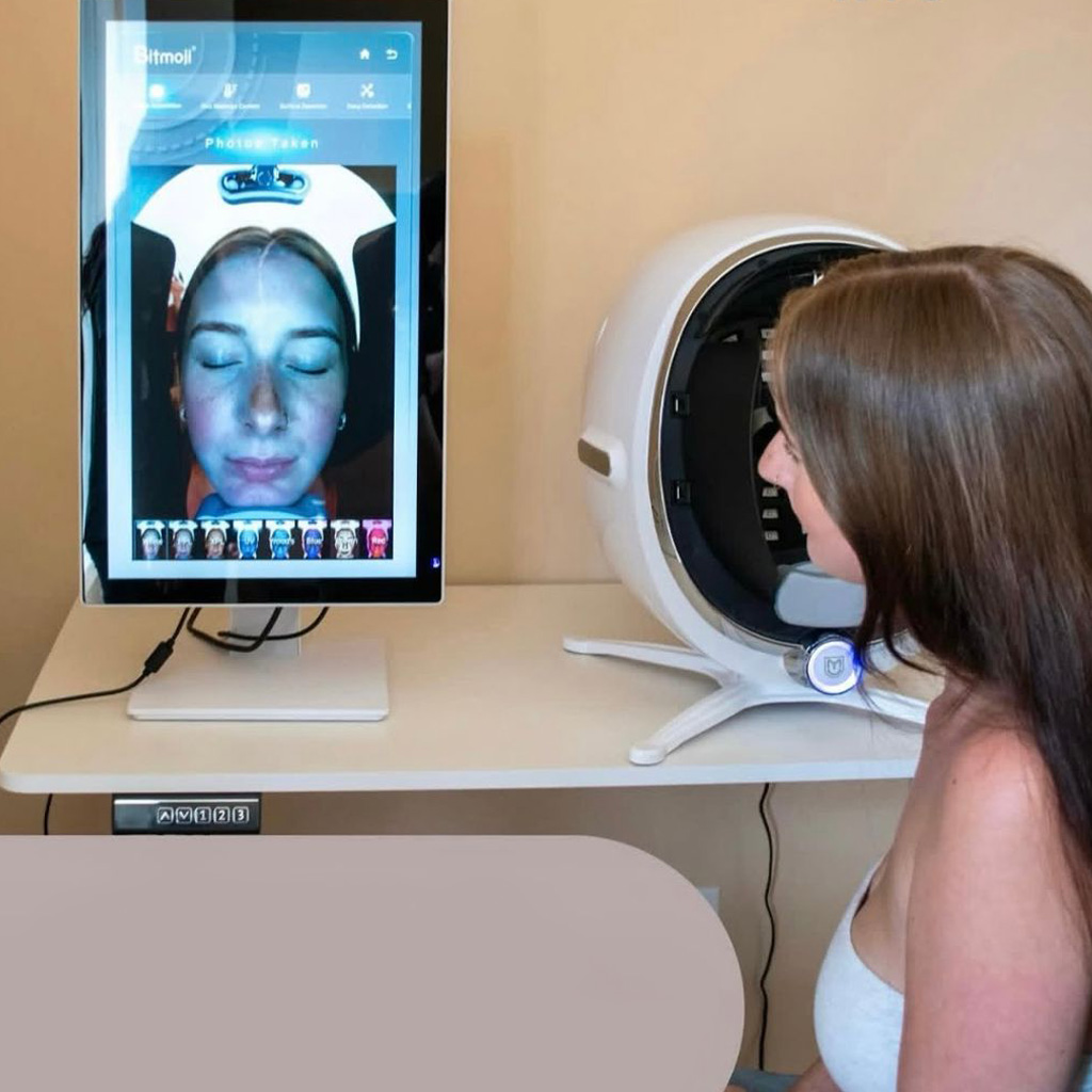 A client seated at ZClinic's AI skin scanner, with the facial scan shown on the screen beside it